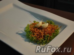 На тарелку выложить листья салата, сверху уложить картофель пай. На картофель выложить разрезанное пополам отварное яйцо перепелки.