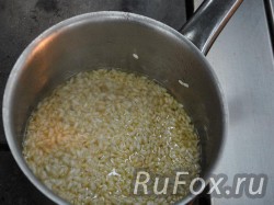 Добавить мясной бульон и варить на медленном огне до готовности (аль денте - чтобы рис немного хрустел).