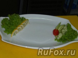 Украсить тарелку зеленью, лимоном, помидором черри и огурцом.