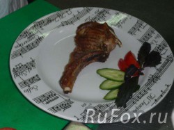 Выложить мясо на тарелку украшенную помидором, огурцом и зеленью.