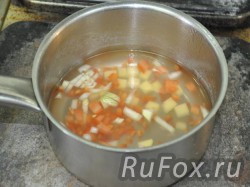 Уложить все ингредиенты, кроме рыбы, в кастрюлю, залить водой и варить до готовности.