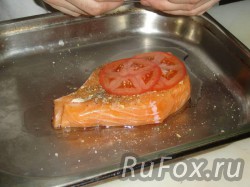 Добавить соль, перец, рыбную специю. уложить на рыбу кольца помидора.