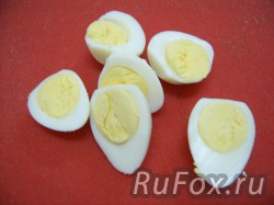 Отварить, почистить и порезать пополам перепелиные яйца.